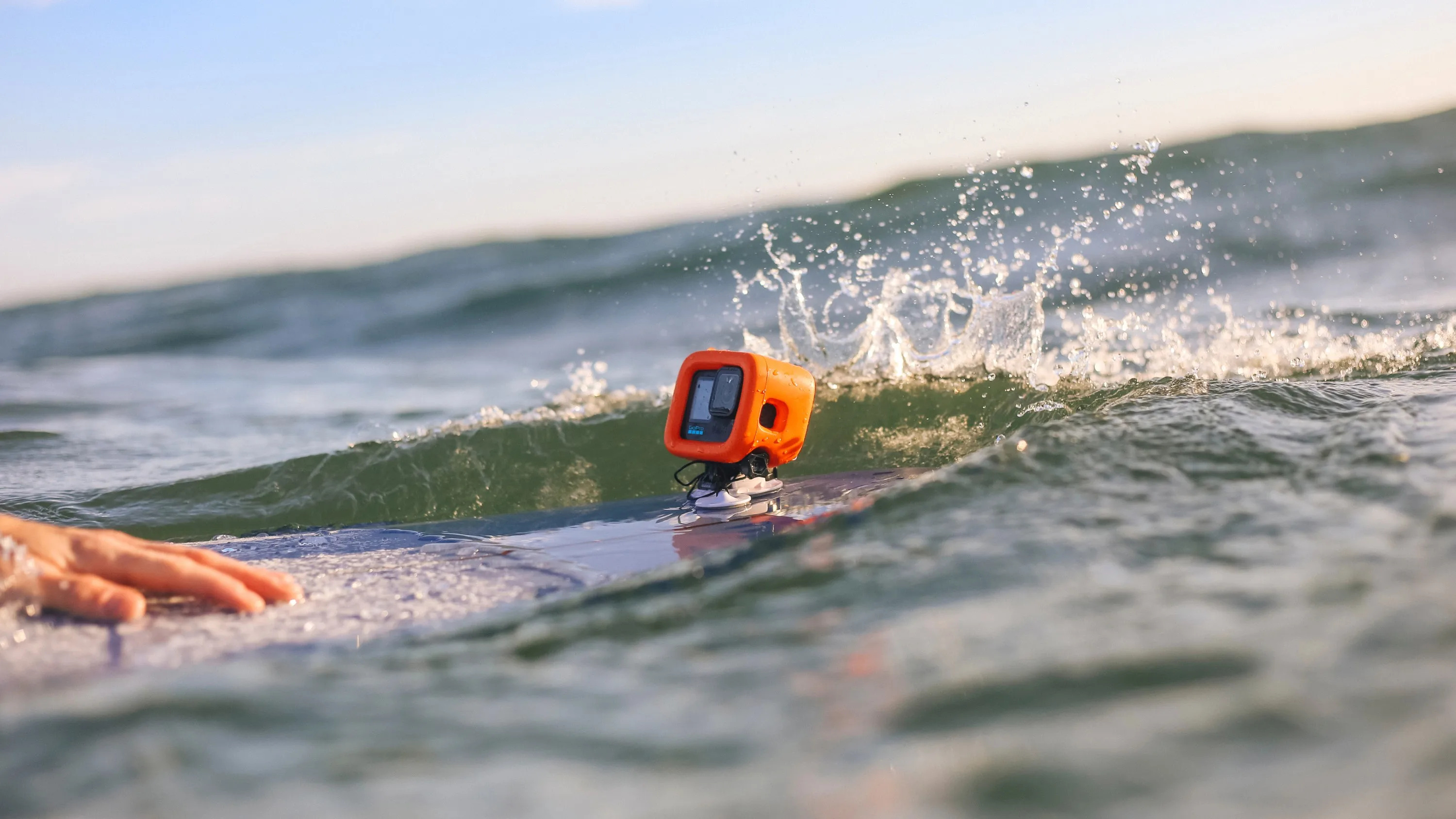 GoPro floating in the surf with a surfer riding a wave behind it